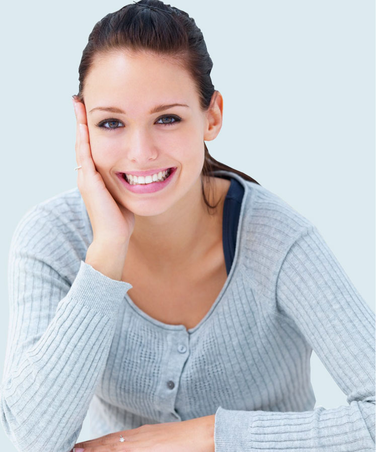 Smiling young woman in a gray cardigan, representing personalized support and care in NDIS respite services at Karma Support.